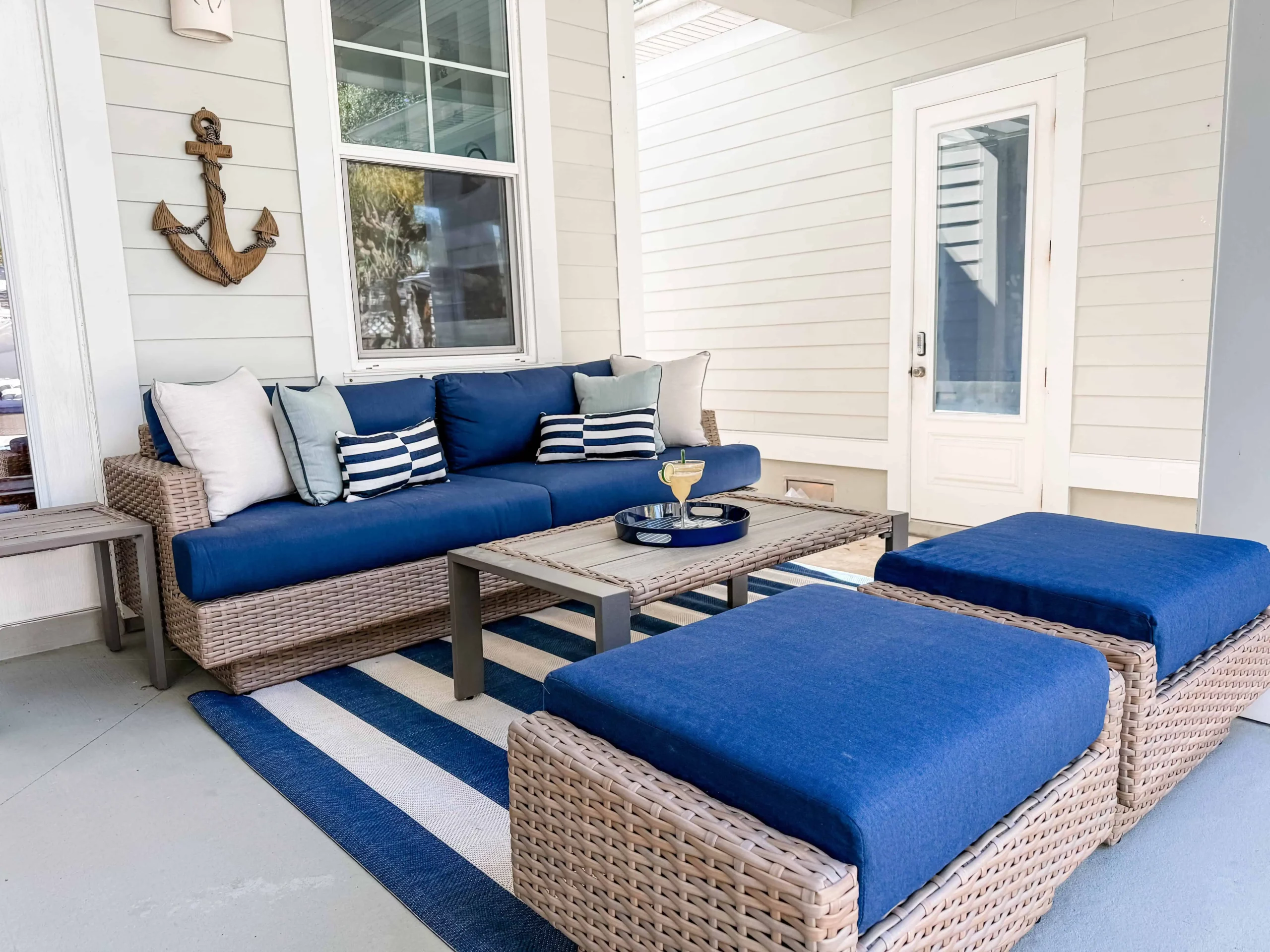 Covered porch with blue outdoor seating and coastal decor at a Luxe Couples Retreat property.