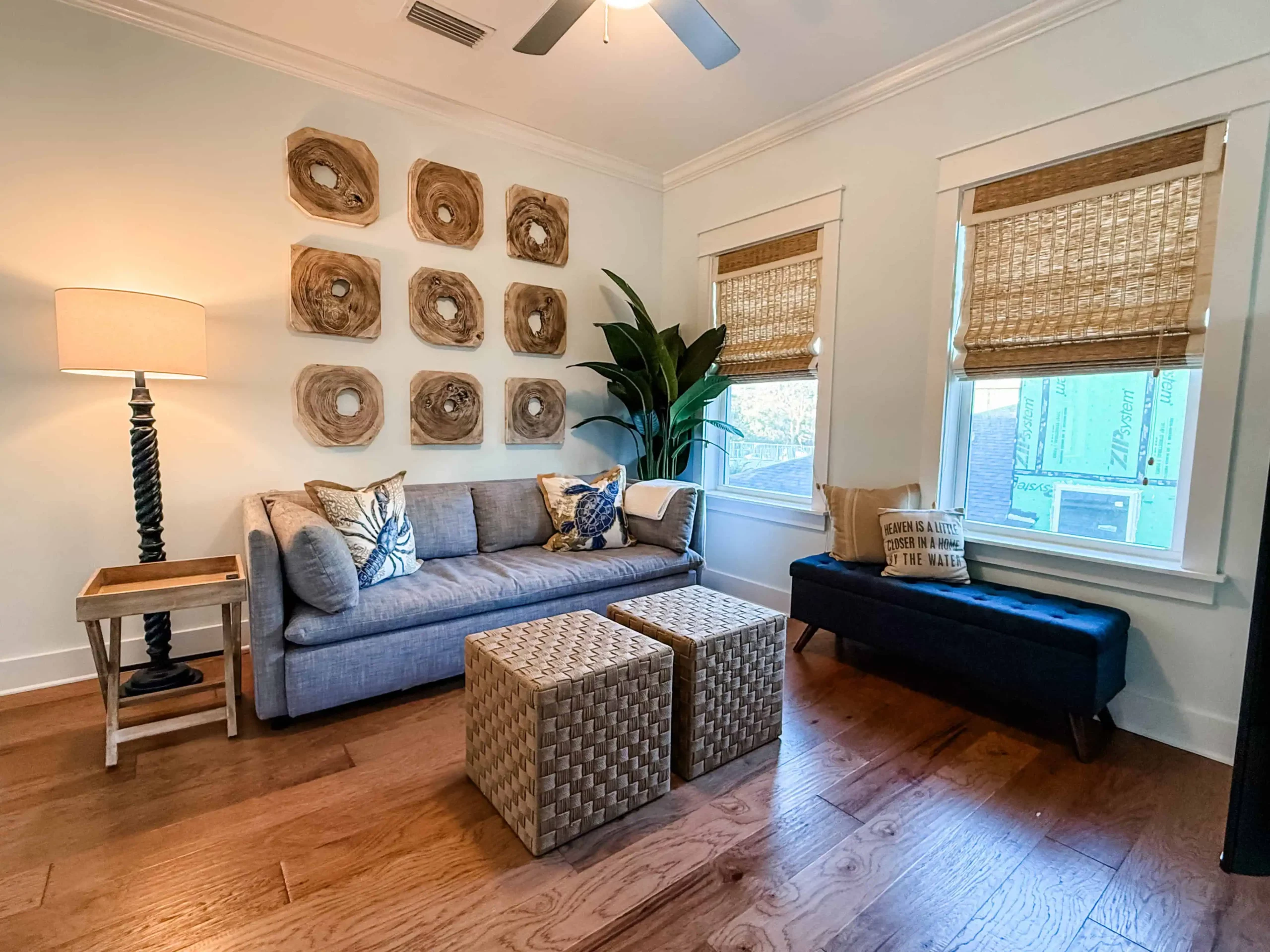 Cozy sitting room with a sofa, woven ottomans, natural wood accents, and coastal decor at a Luxe Couples Retreat property.