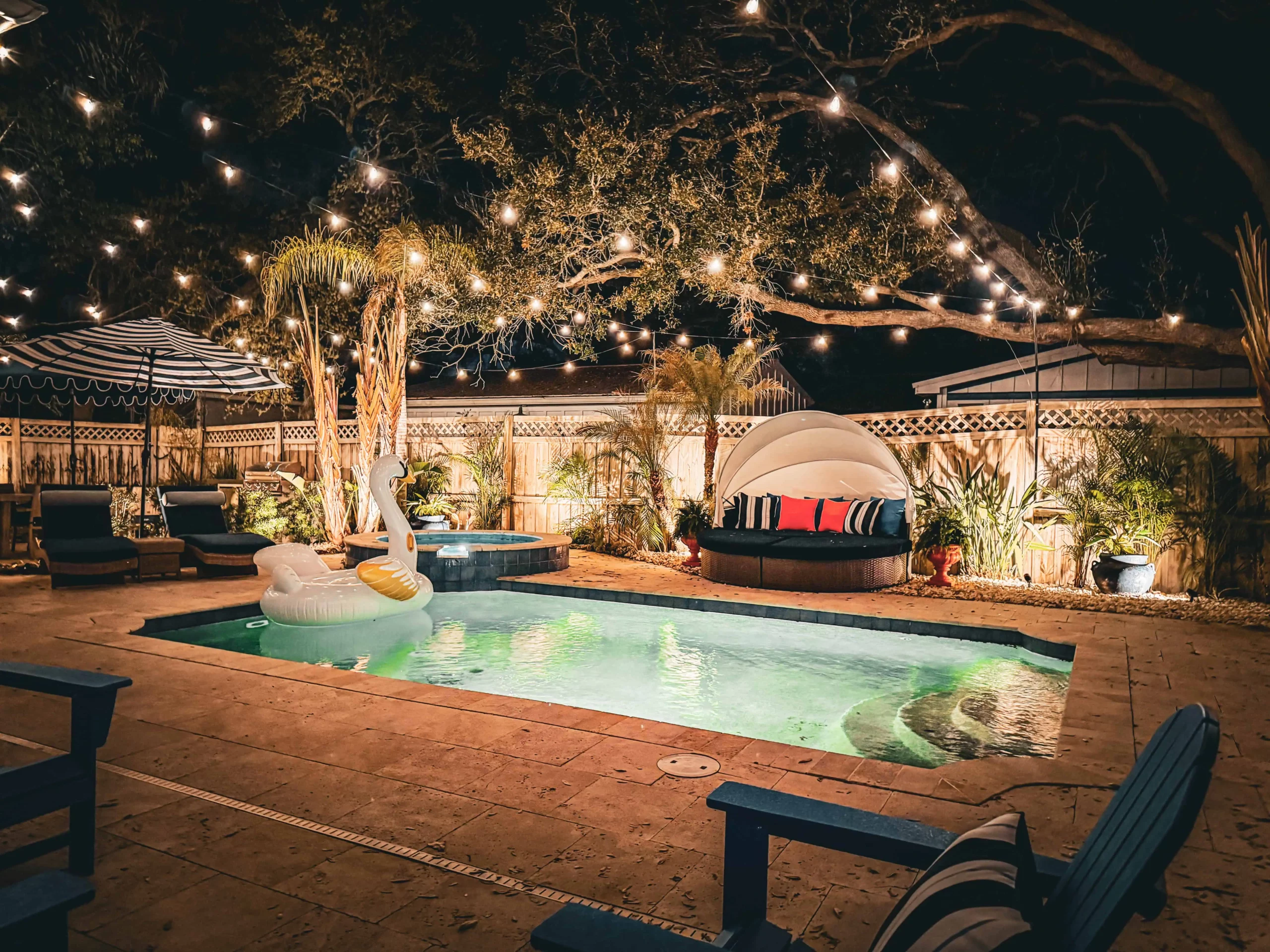 Private pool and hot tub with lounge seating and string lights at a Luxe Couples Retreat property.