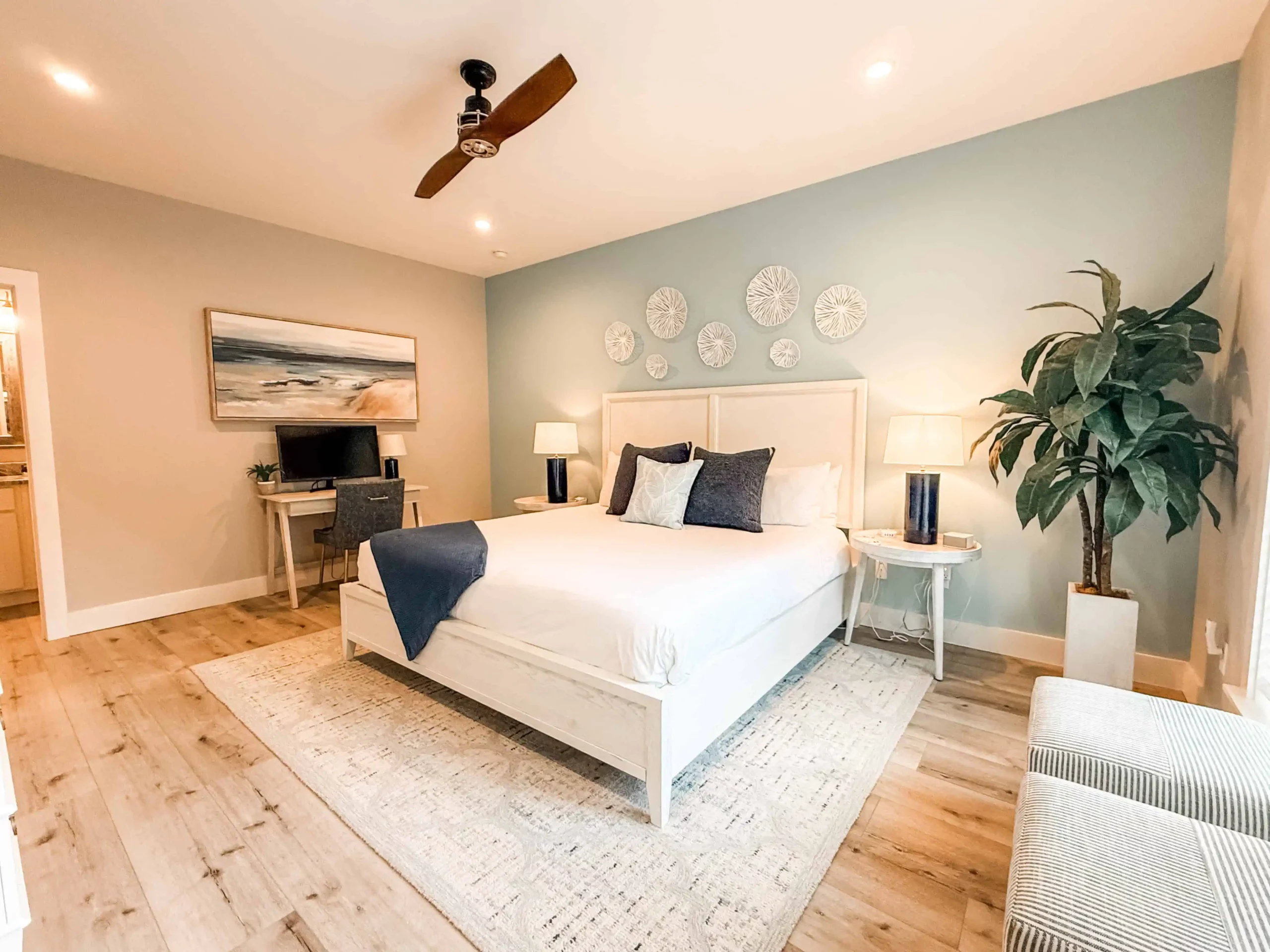 Private bedroom with a king bed, coastal decor, desk, and warm lighting at a Luxe Couples Retreat property.